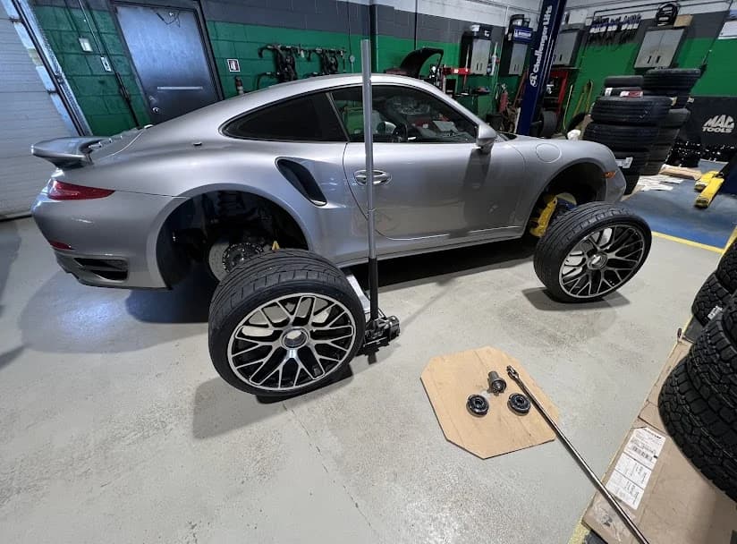 Customer Porsche on the hoist at Quality Lube & Tires